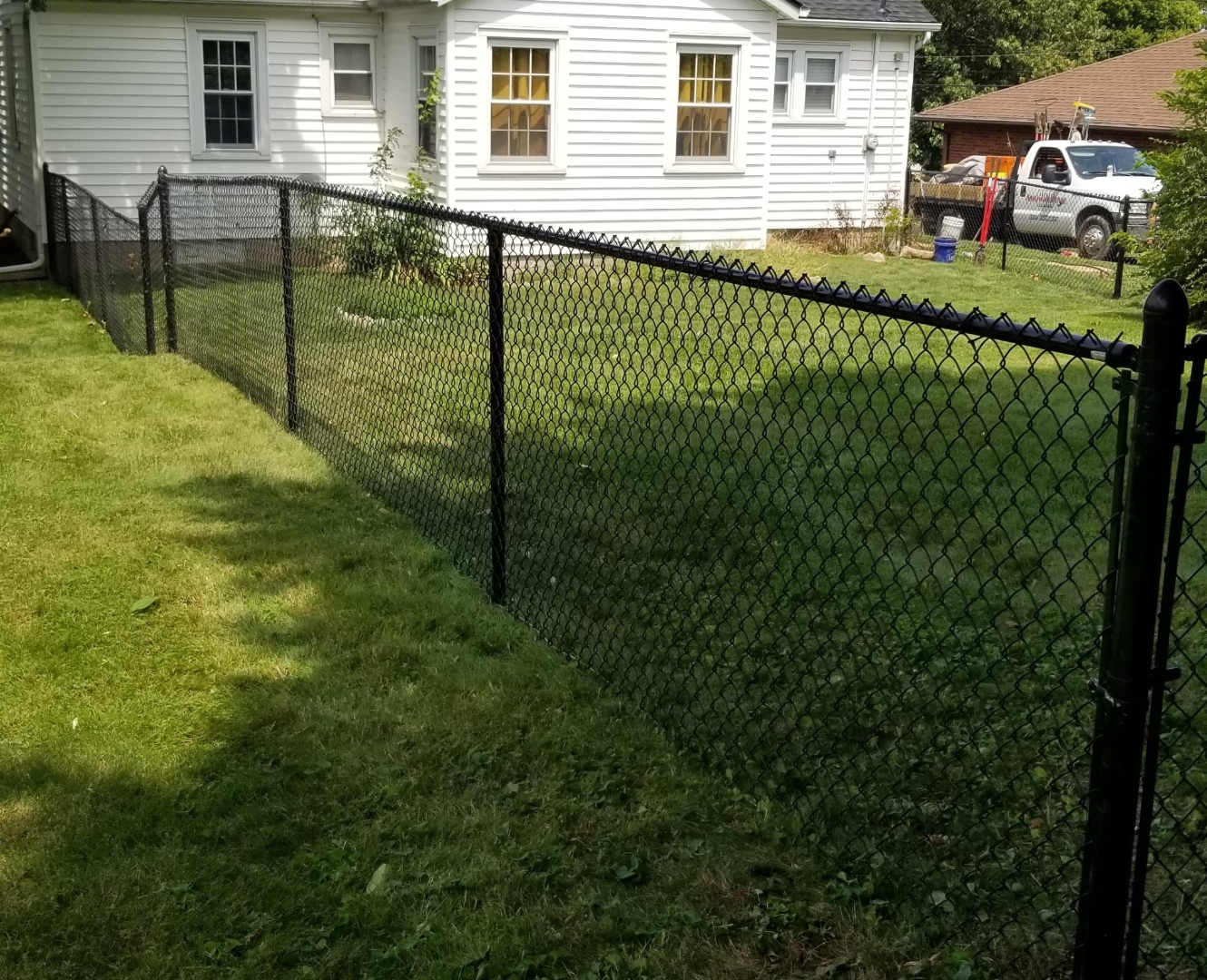 Black vinyl-coated chain link fence installation, Arnold MO
