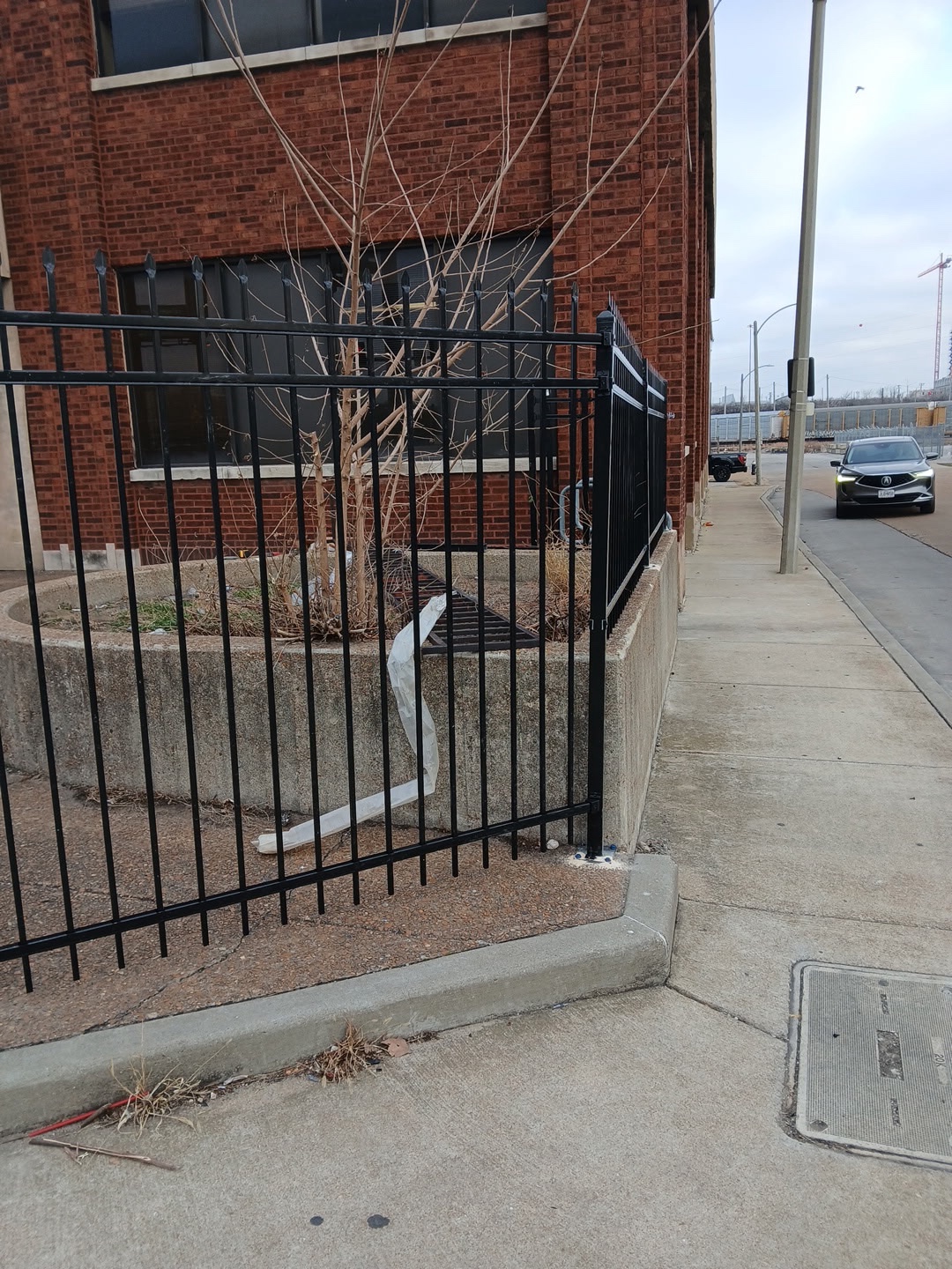 Black ornamental fence on raised concrete planter, commercial property