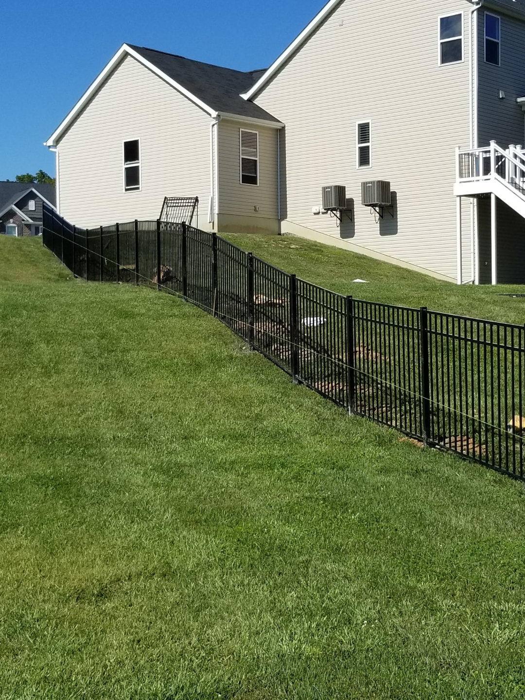 Black ornamental iron fence on sloped yard, Kirkwood MO