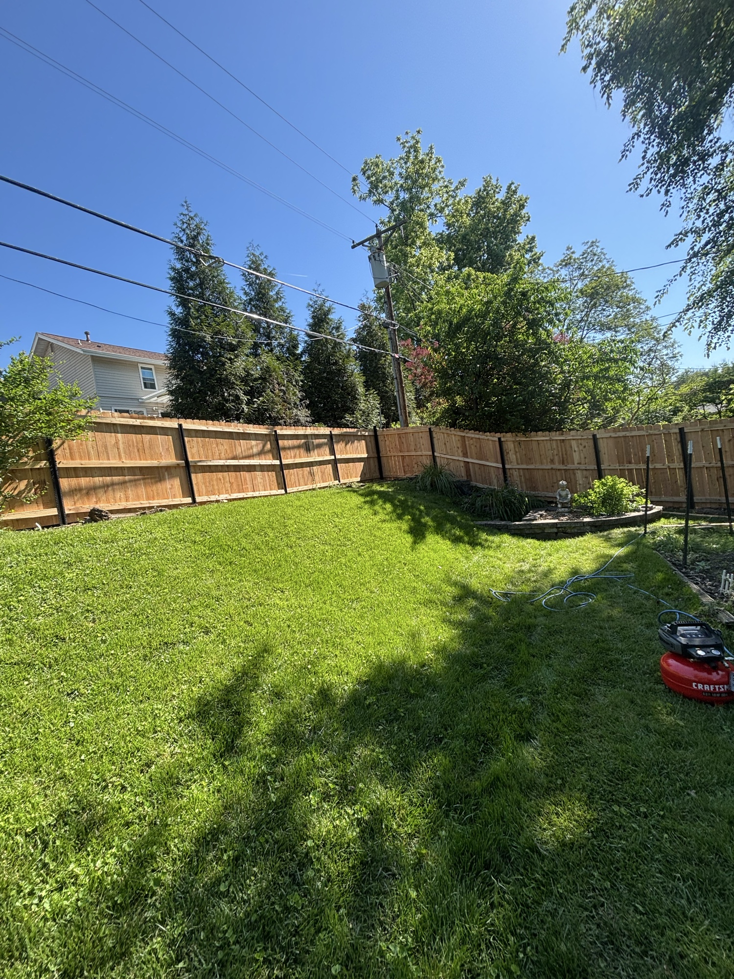 Cedar privacy fence with black steel posts, backyard enclosure