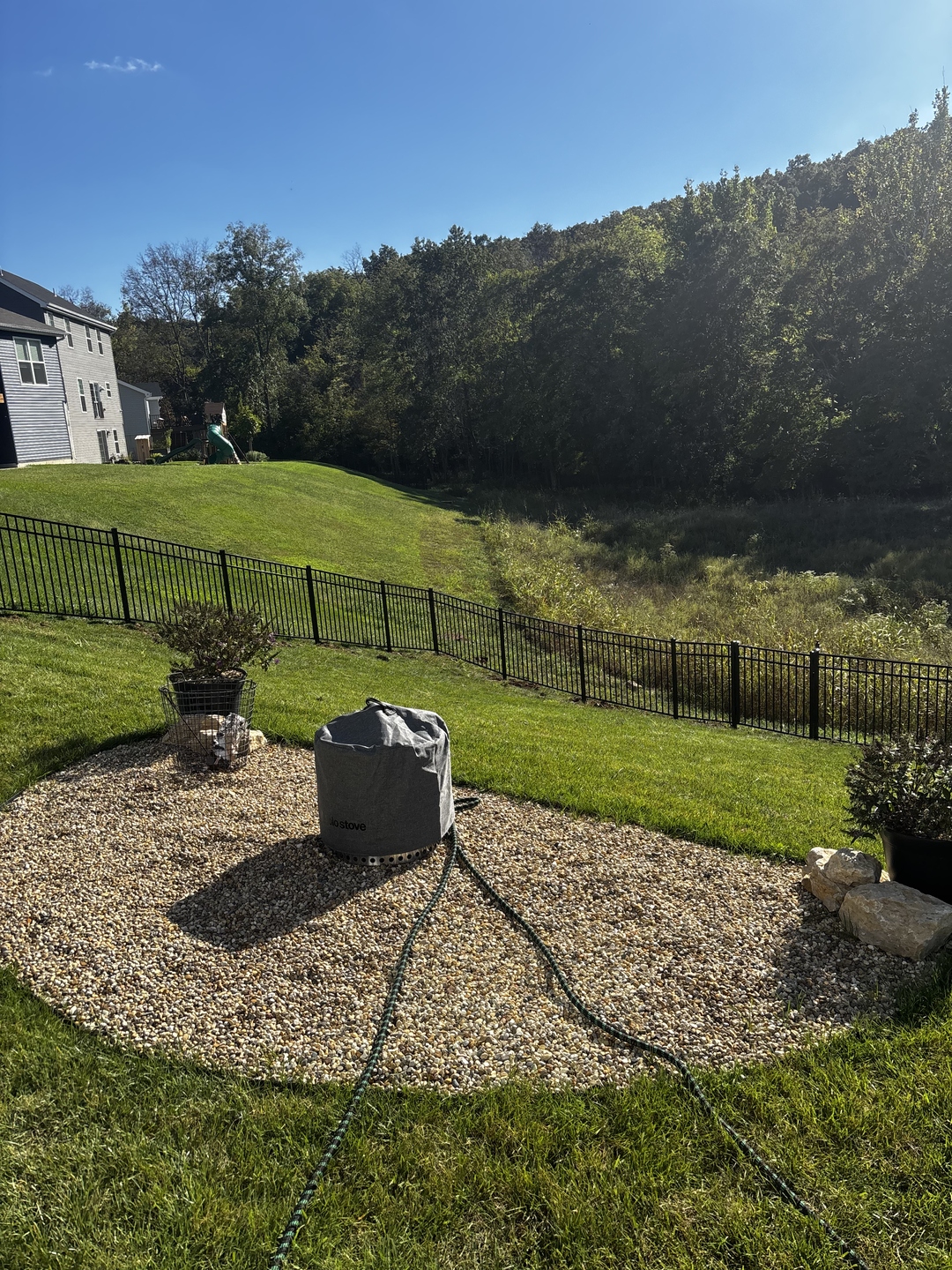 Gravel patio and aluminum fence installation by Verdant Hills