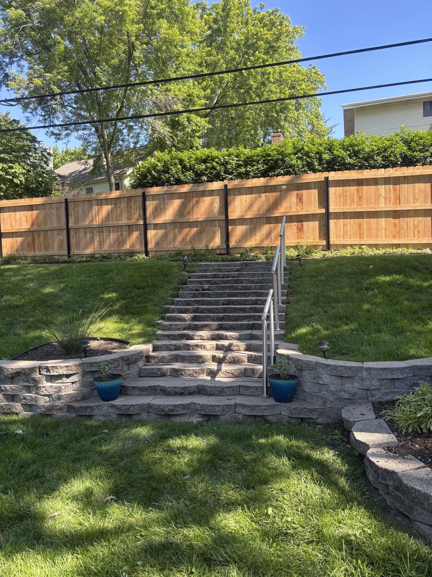 Stone retaining wall with steps and cedar privacy fence